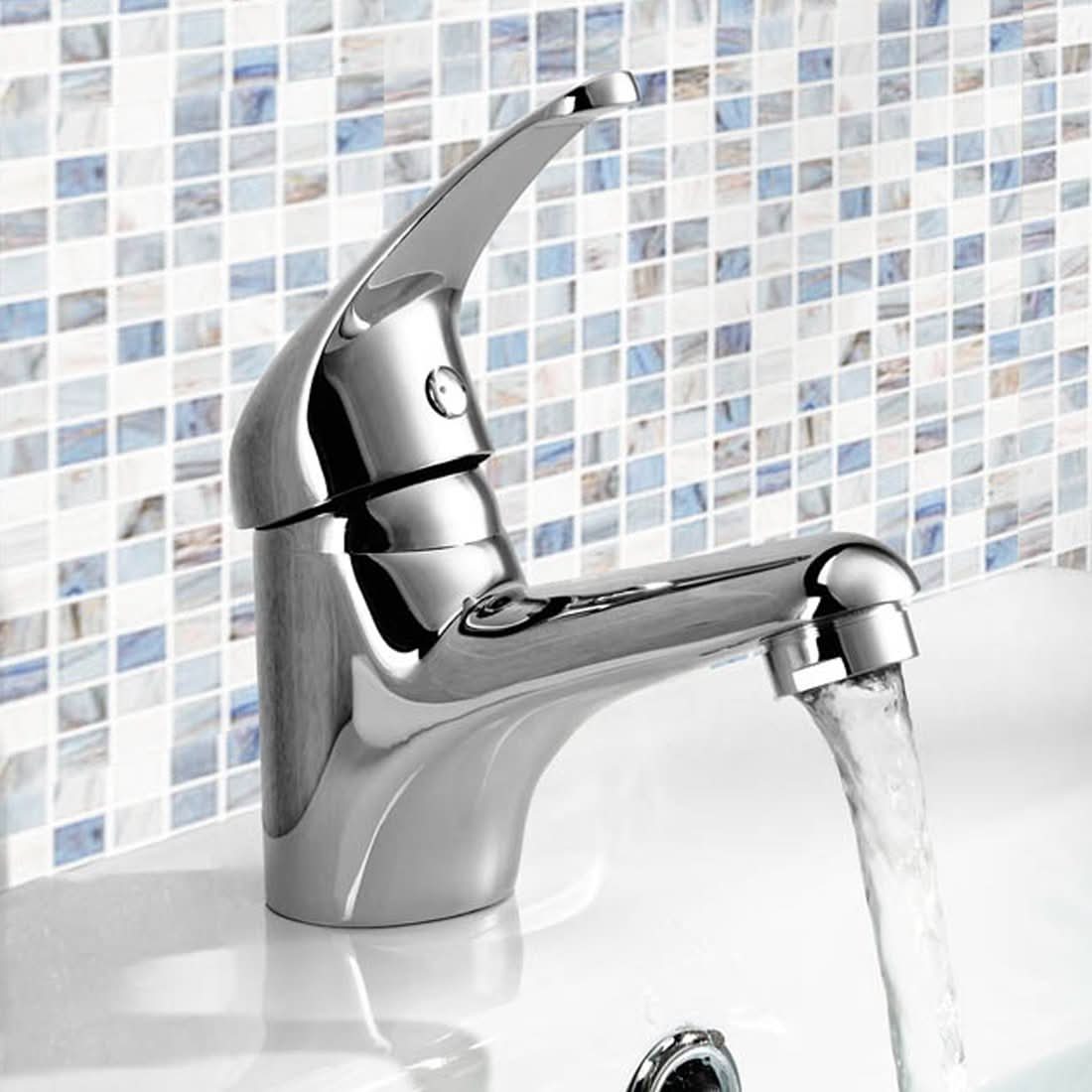 The iBathUK Orvex Monobloc Basin Mixer Tap, a compact chrome lever faucet, runs water into a white basin set against a blue and white mosaic tile backsplash, adding modern style to your bathroom.