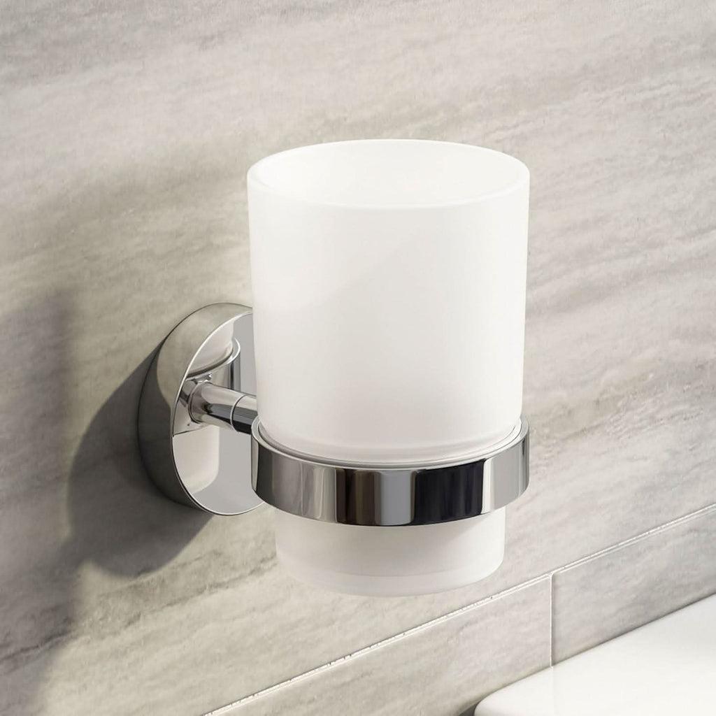 The iBathUK Lumo Designer Bathroom Accessory Set features a wall-mounted chrome toothbrush holder with a frosted glass tumbler, shown attached to a light gray tiled bathroom wall above a white surface.