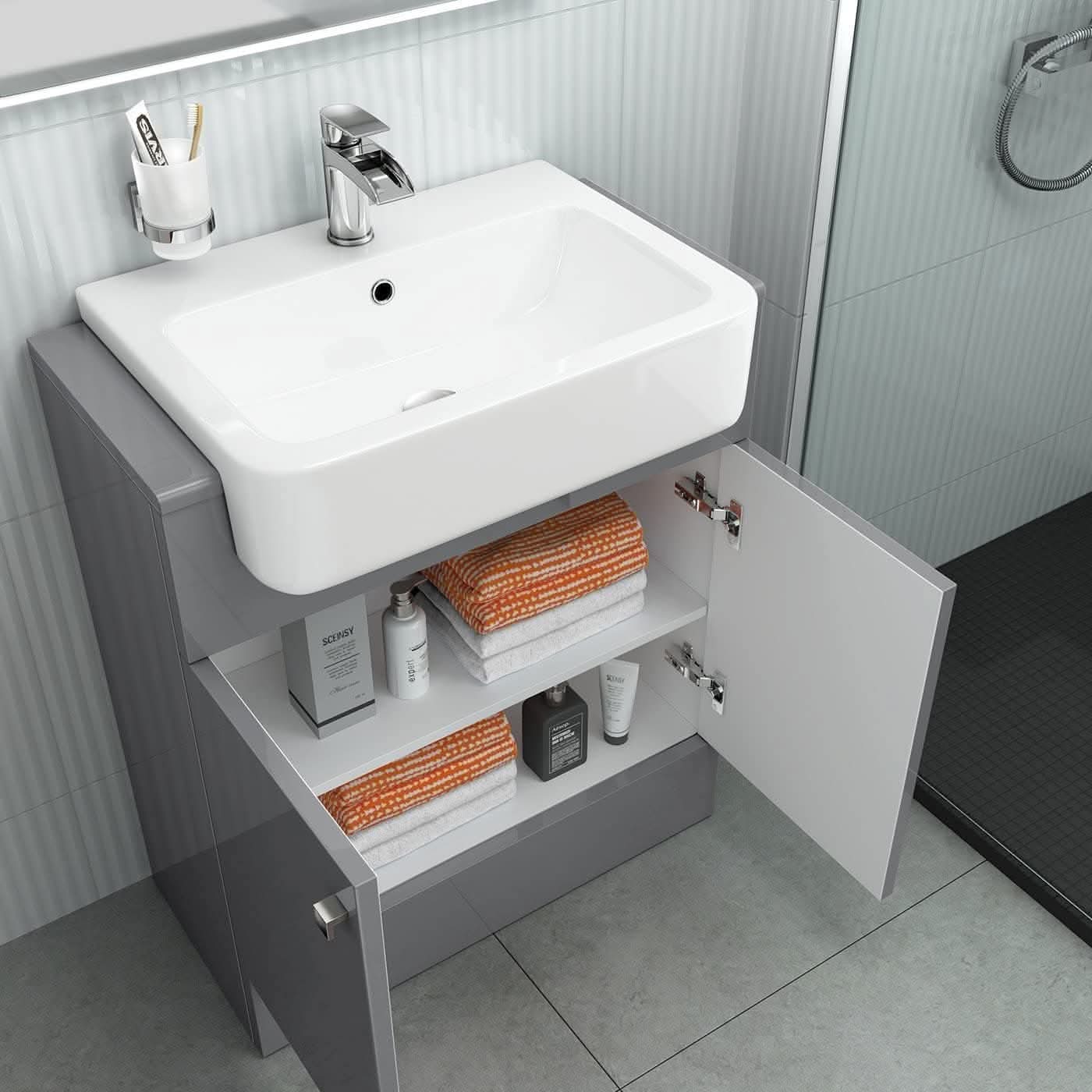 The iBathUK Harper 2 Door Floorstanding Vanity Unit With Semi Recessed Basin (660mm x 800mm) is shown with open doors displaying orange and white towels and toiletries. A wall-mounted toothbrush holder and a nearby shower area are also visible.